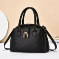 Sac à main élégant noir grainé avec fermoir doré et bandoulière sur une table minimaliste - Noir