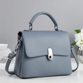 Elegante bolso de mano azul bruma en cuero litchi con cierre plateado y asa superior - Azul