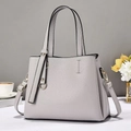 Vue détaillée du sac à main en cuir grainé gris clair avec anneau doré sur table - Gris