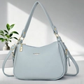 Détail du sac bleu clair en cuir grainé avec fermeture éclair dorée et logo doré - Bleu