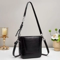 Detail of glossy black shoulder bag featuring textured patent leather and silver hardware - Black
