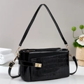 Macro detail of black patent leather texture with crocodile pattern and golden metal twist lock - Black
