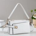 Detail of white crocodile texture leather handbag with elegant gold metal hardware accents - White