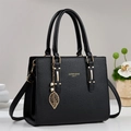 Elegante bolso de mano en cuero negro con grano lichi, herrajes dorados y colgante - Negro