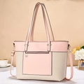 Close-up of pink and beige woven tote bag with adjustable shoulder strap and zip pocket - Pink
