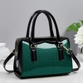 Macro view of green sequin texture and black patent leather on the Boston bag - Green