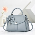 Retro light blue crossbody bag with bow pearl charm and textured leather finish - Blue