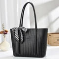 Detail der schwarzen Shopper-Tasche mit Fischgrätmuster und Seidenschal auf weißem Tisch - Schwarz
