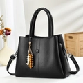 Minimalistische schwarze Handtasche aus Leder mit Lychee-Muster und Perlenquaste - Schwarz