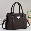 Elegant dark brown handbag with herringbone texture and silver lock from a 45-degree angle - Coffee