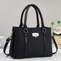 Elegant black herringbone tote bag with leather handles and silver clasp on beige background - Black