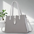 Detail of grey bucket bag showing woven texture and silver buckle in natural light - Gray