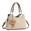 Detail of woven straw tote bag with brown leather handles and plush cloud charm - Khaki