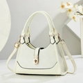 Sac à main élégant beige et gris avec fermoir doré sur un présentoir blanc minimaliste - Blanc pur