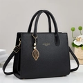 Elegante schwarze Handtasche aus Leder mit goldener Logo und Perlen-Blatt-Anhänger - Schwarz
