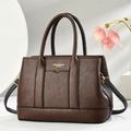 Dettaglio di borsa tote in pelle marrone martellata con hardware dorato e tracolla - caffè