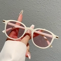 Dettaglio di occhiali da sole oversize bianco crema con inserti dorati e lenti viola - Montatura Bianco Crema Lenti Rosa Chiaro