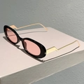 Detalle de gafas de sol ovaladas de moda con montura negra y varillas doradas en zigzag - Montura Negra Lentes Rosas
