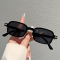 Primer plano de gafas de sol rectangulares de plástico negro con detalles de metal dorado - Montura Negra Lentes Gris Negro