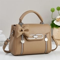 Close-up of khaki pebbled leather handbag with large bow and decorative pearl chain - Khaki