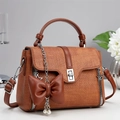 Brown woven texture handbag with bow pearl charm and silver twist lock in side view - Khaki/Earth Yellow