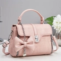 Pink tweed handbag with leather bow and pearl charm shown from a 45-degree angle view - Pink