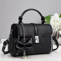 Detail of black woven texture handbag with silver lock and bow pearl pendant charm - Black