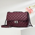 Detailed view of burgundy quilted crossbody bag with silver lock and chain strap - Red Brown