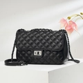 Detailed view of black quilted leather texture and silver chain strap on flap bag - Black