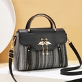 Elegante borsa a mano in tessuto con ciondolo a cigno dorato e manico in metallo - Nero