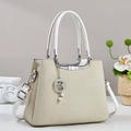 Bolso bandolera beige elegante con colgante de perla lunar en ambiente moderno - Blanco Roto