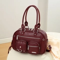 Detalle de bolso mensajero en cuero burdeos con bolsillos de cremallera plateados - Rojo