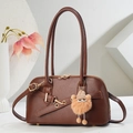 Deep brown semi-circular faux leather handbag with plush charm on white background - Brown