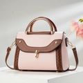Sac à main bicolore rose et marron avec fermoir doré sur un support minimaliste - Rose