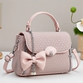 Détail du sac à main rose avec nœud en cuir, boucle M en métal et pendentif étoile - Rose