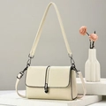 Minimalist beige pebble leather crossbody bag with elegant black orb lock and dual straps - Beige