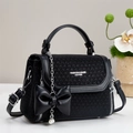Detalle de bolso bandolera tejido negro con colgante de lazo de perlas y cadena - Negro