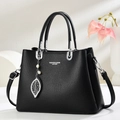 Elegante borsa in pelle nera con finiture argentate e pendente a foglia con perla - Nero