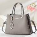 Détail du sac à main gris en cuir grainé avec chaîne argentée et pendentif perle feuille - Gris