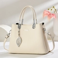 Dettaglio borsa a mano beige in pelle martellata con catena argento e ciondolo perla - Bianco Sporco