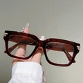 Nahaufnahme der Retro-Brille mit dunkelbraunem Rahmen und goldenem Dreifach-Streifen-Detail - Transparenter brauner Rahmen Transparente Gläser