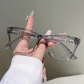 Detail of transparent grey square frame glasses with gold metal accents on the hinge - Clear Gray Frame Clear Lens