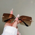 Detalle de gafas de sol sin montura con perlas decorativas y patillas metálicas doradas - Degradado Marrón Marco Dorado Con Perla