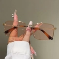 Détail de lunettes de soleil carrées dorées avec branches torsadées et décor en cœur - Monture Dorée Verres Champagne