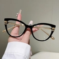 Detail der Cat-Eye-Brille mit schwarzem Glanzfinish und schmalen Goldmetallbügeln - Schwarzer Rahmen mit klarer Linse und Goldteilen
