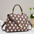 Detail der Handtasche mit geometrischem Muster, Lederbesatz und goldenem Drehverschluss - Kaffeebraun