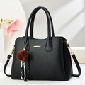 Classic black leather tote bag with gold metal detail, pompom charm and striped ribbon - Black