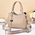 Chic beige tote bag with Greek fret metal trim and heart charm on a patterned strap - Light Khaki