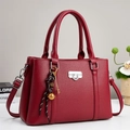 Dettaglio borsa in pelle bordeaux a grana di litchi con chiusura argento e ciondolo - Rosso