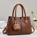 Elegant brown woven leather tote bag with a mini wallet charm on a minimalist background - Earthy Yellow
